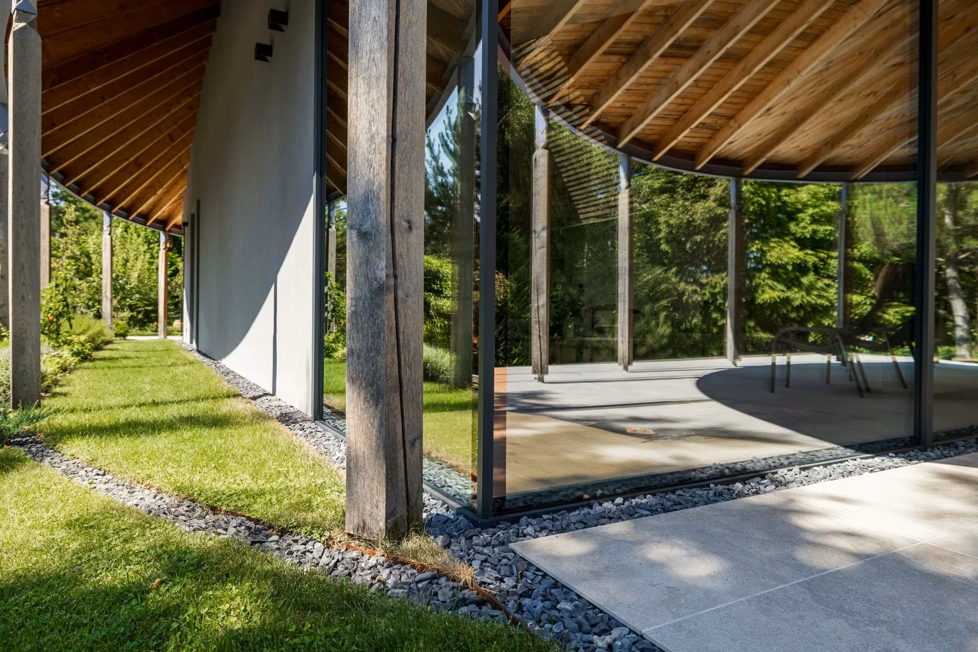 Exterior glazed corner with aluminium frames, timber columns and a terrace.