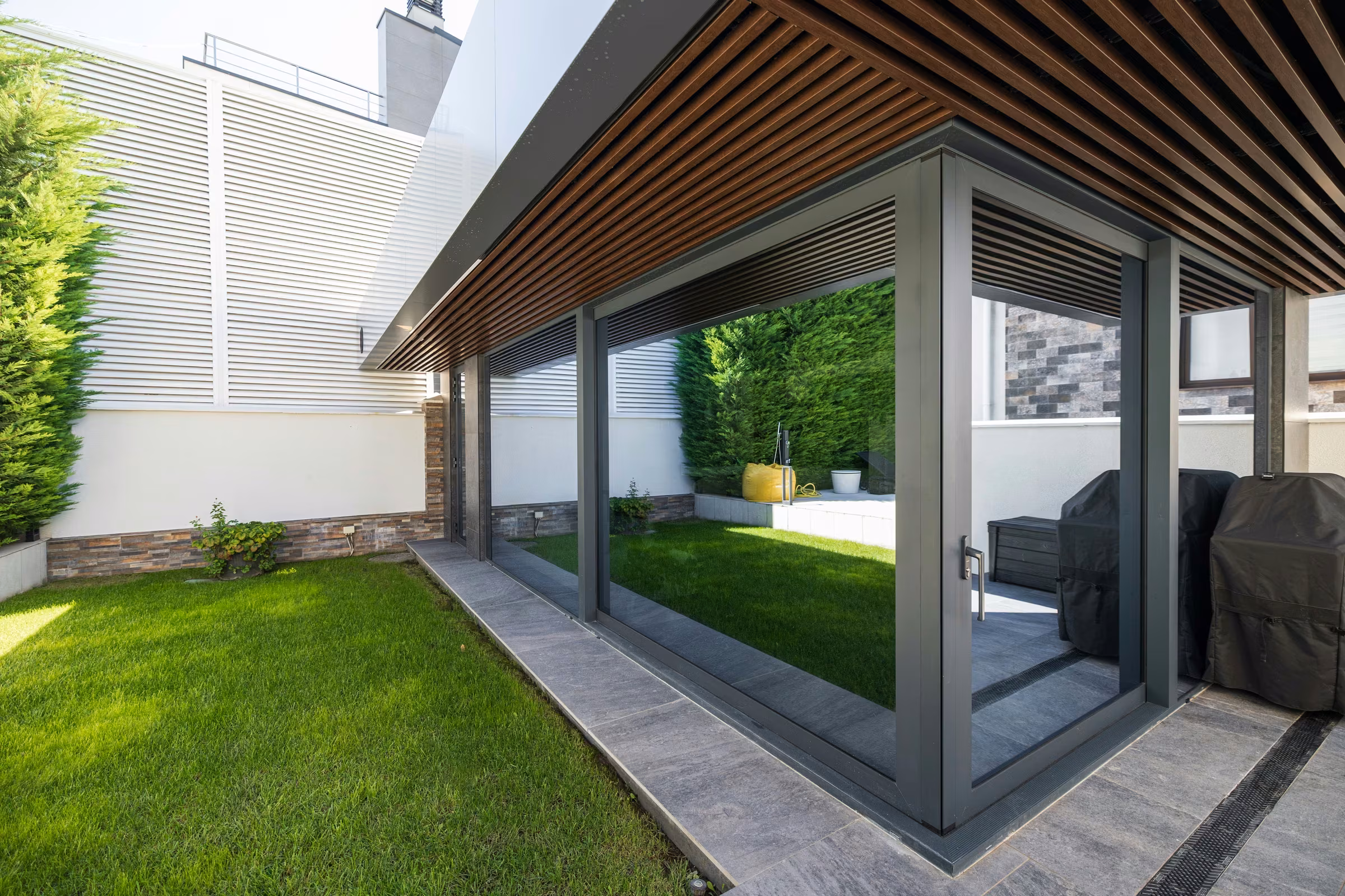 Glazed terrace seen from outside, with large glass surfaces integrated into its architecture.