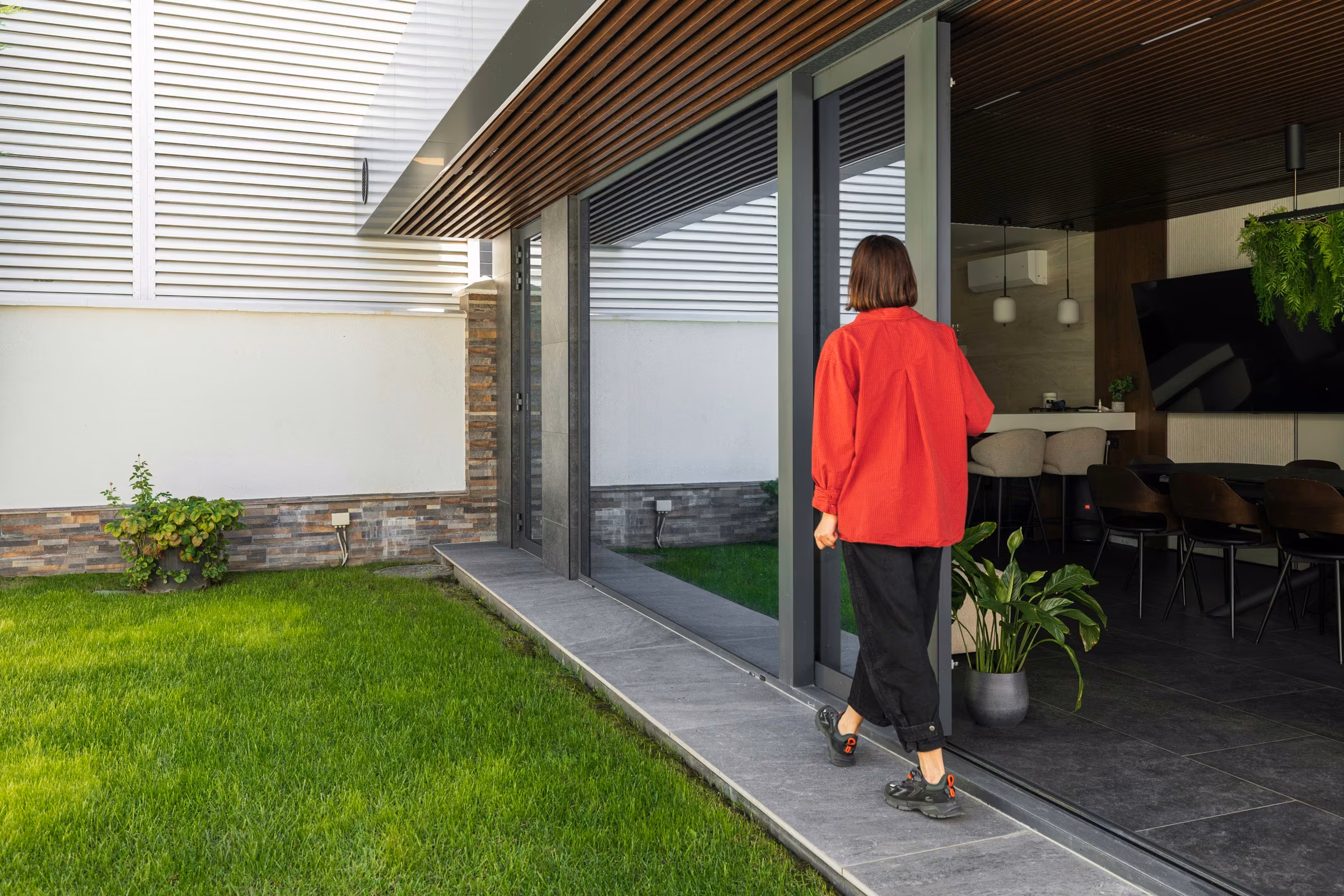 View of the terrace's glazed opening with sliding systems and anthracite frames.