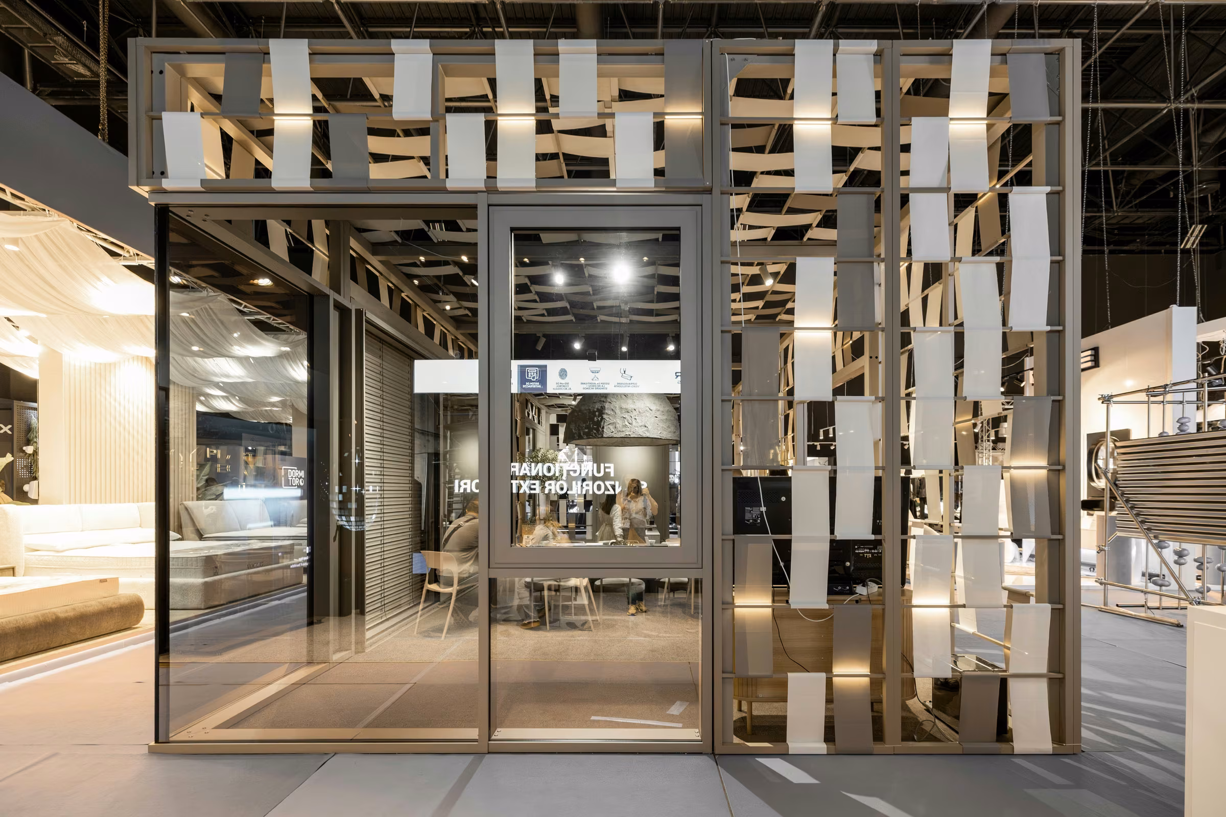 Entrance to the exhibition stand, with glazed frontage and a decorative modular timber structure.
