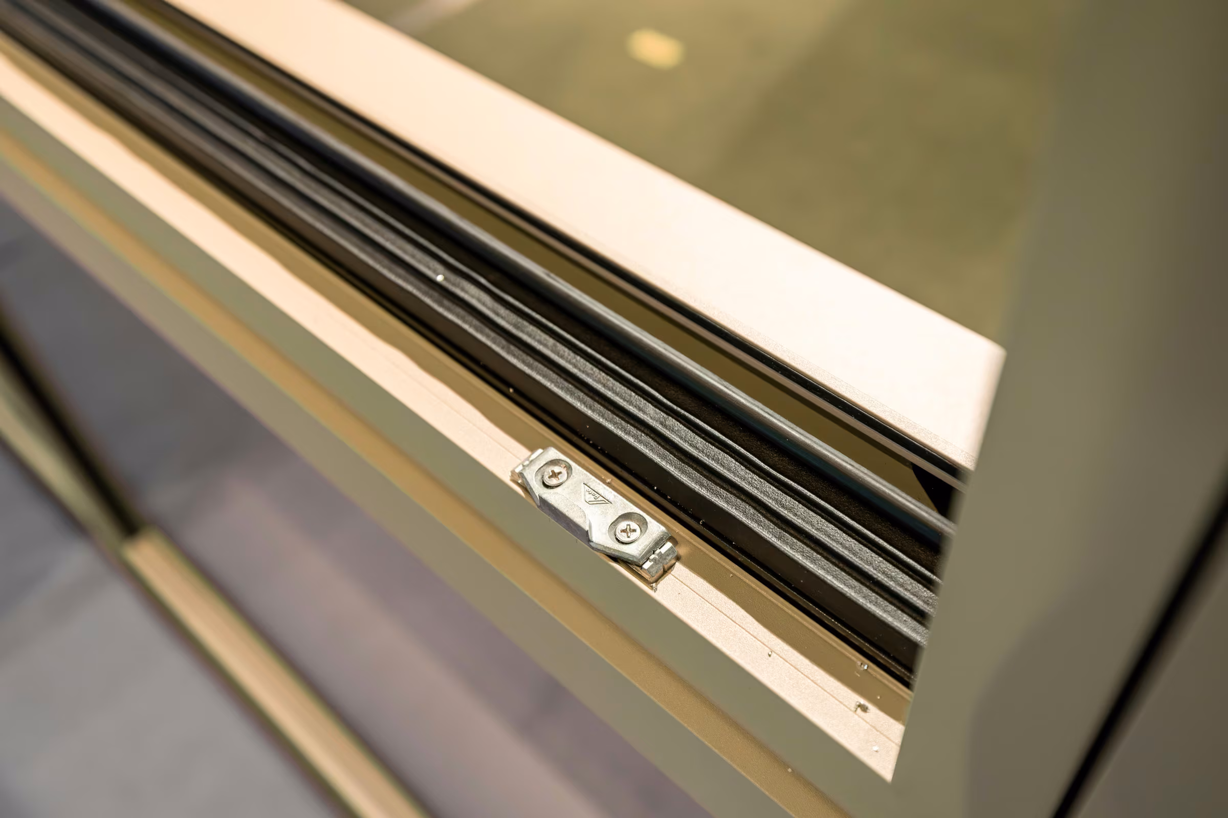 Close-up of window hardware and the lower frame of a movable sash.