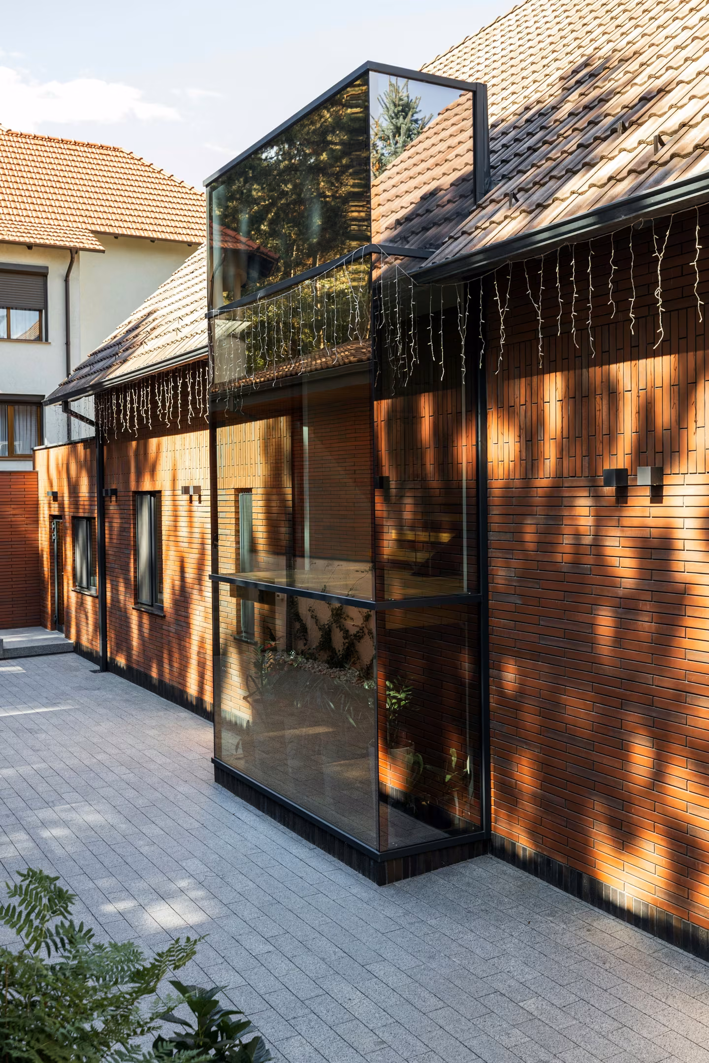 The glazed volume complements the home's geometry.