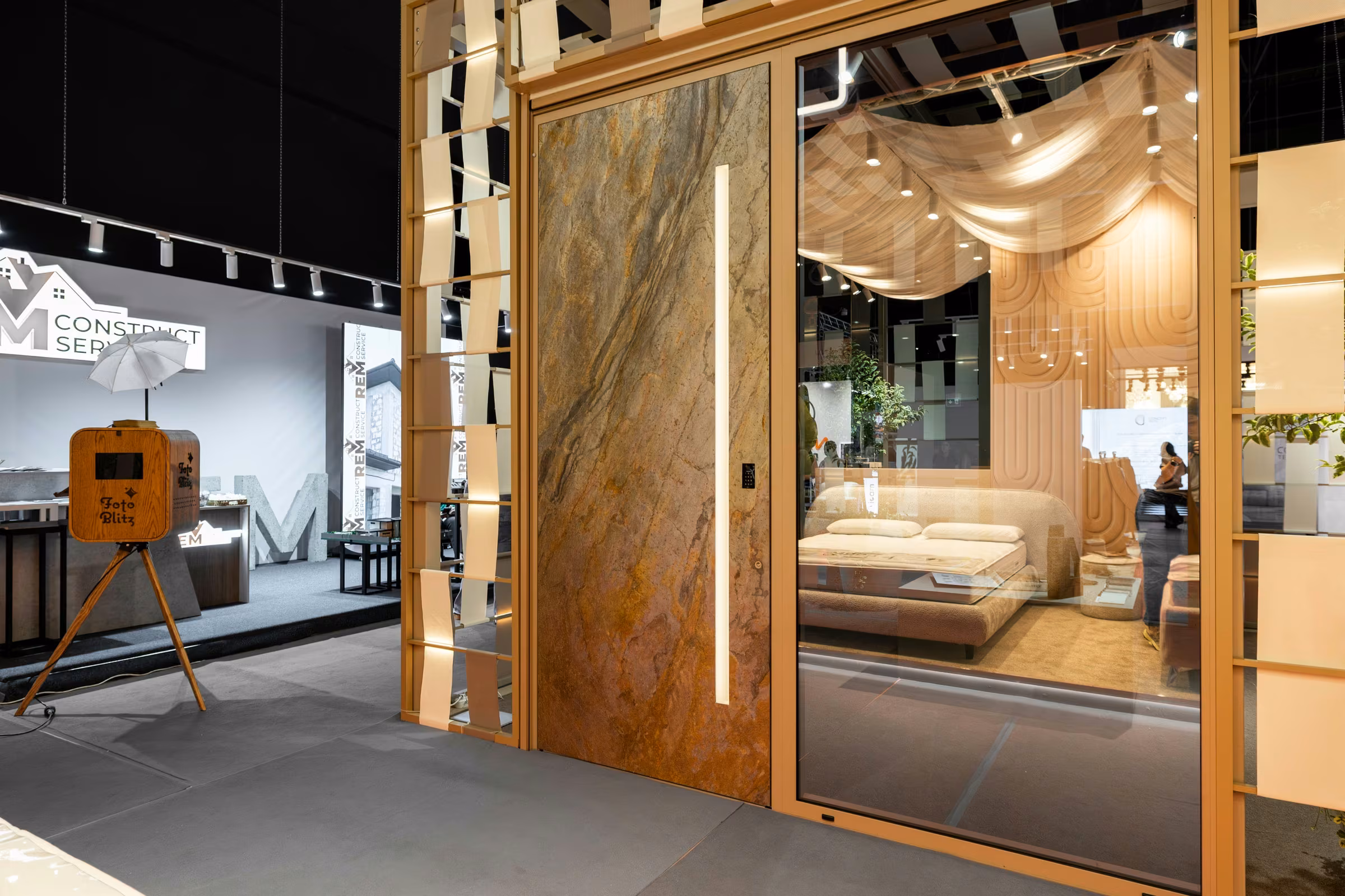 Plastregal exhibition stand with a stone-look door panel, expansive glazing and a decorative timber structure.